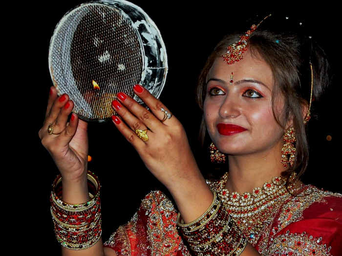 Indian young woman looking through sieve during karwa chauth Stock Photo -  Alamy